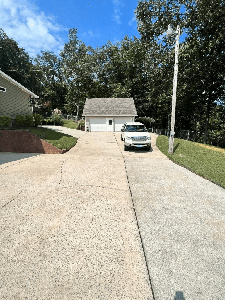 Before and after concrete driveway pressure washing showing clean and dirty sections side by side